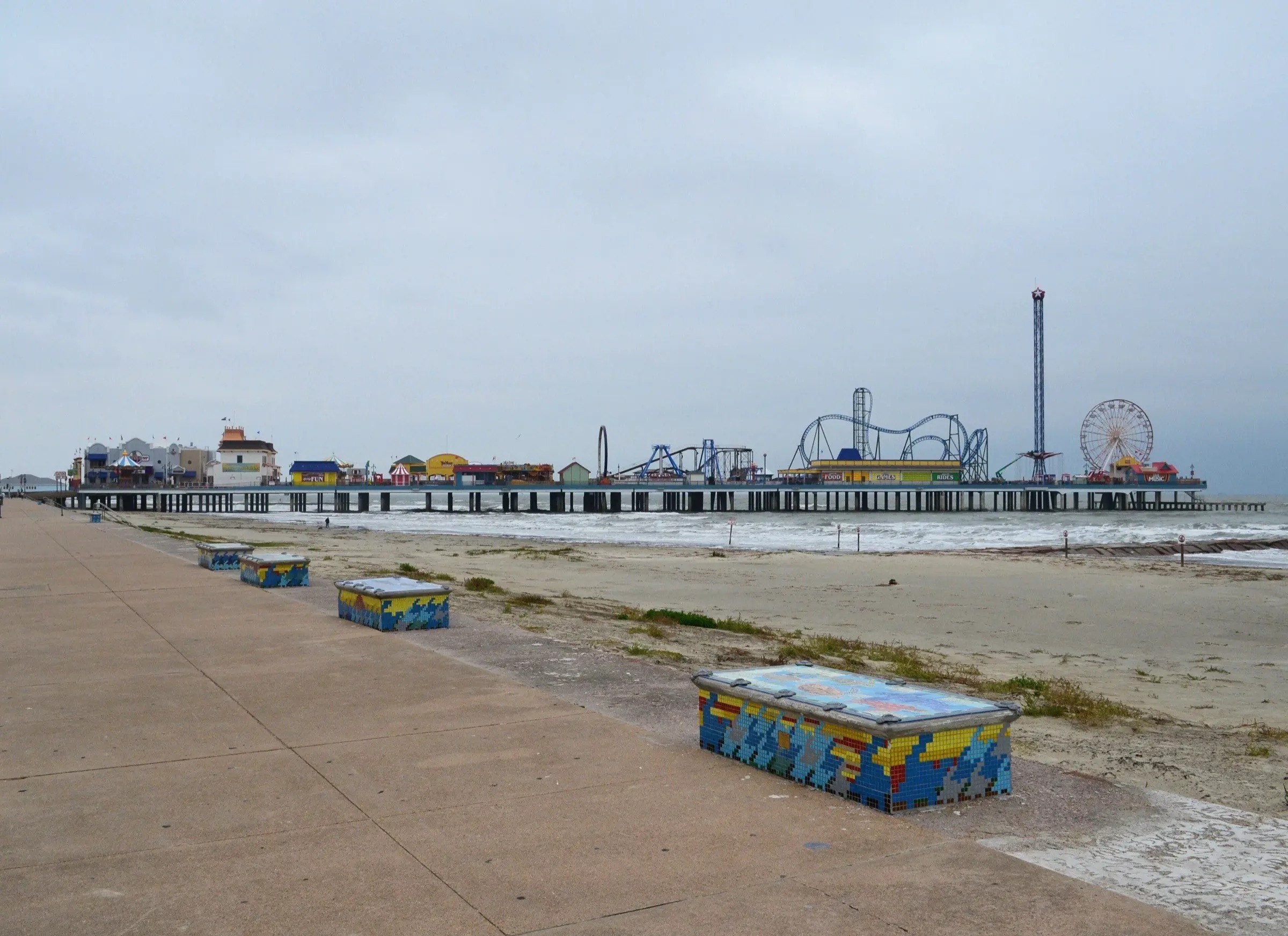The beach below the Galveston Seawall, with Pleasure Pier in the distance